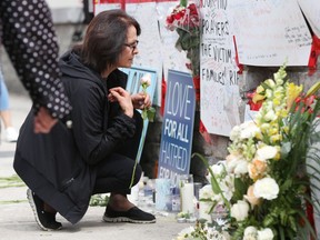 A woman prays on April 24, 2018 at a makeshift memorial for victims in the van attack in Toronto, Ontario.  A van driver who ran over 10 people when he plowed onto a busy Toronto sidewalk was charged with murder Tuesday.