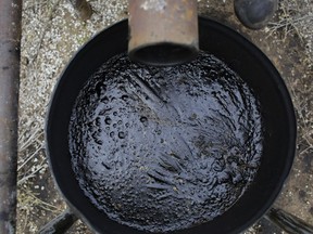 An overflow barrel holds oil near a storage tank.