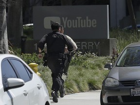 Officers run toward a YouTube office in San Bruno, Calif., Tuesday, April 3, 2018. Police and federal officials have responded to reports of a shooting Tuesday at YouTube headquarters in Northern California.