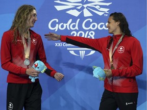 Women's 200m backstroke gold medalist Canada's Kylie Masse, right, embraces silver medalist and compatriot Taylor Ruck, left, on the podium at the Aquatic Centre during the 2018 Commonwealth Games on the Gold Coast, Australia, Sunday, April 8, 2018.