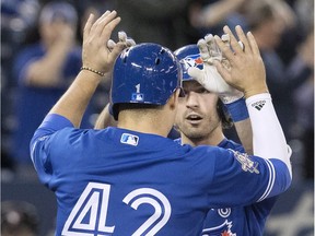 Toronto Blue Jays' Randal Grichuk, right, celebrates with teammate Aledmys Diaz at home plate after Grichuk hit a three-run home run against the Kansas City Royals in the sixth inning of the first game in their American League MLB baseball doubleheader in Toronto on Tuesday April 17, 2018.