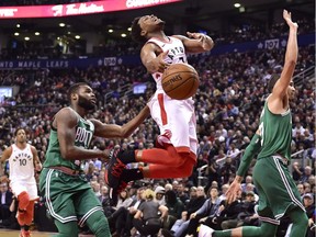 Toronto Raptors guard Kyle Lowry (7) is fouled by Boston Celtics forward Jayson Tatum (right) as he goes to the basket by guard Kadeem Allen (left) during second half NBA basketball action in Toronto on Wednesday, April 4, 2018.