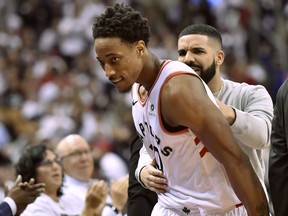 Toronto Raptors guard DeMar DeRozan (10) is embraced by Toronto-born rapper Drake as he's pulled to the bench in the final minutes of second half NBA basketball action against the Washington Wizards, in Toronto on Tuesday, April 17, 2018.
