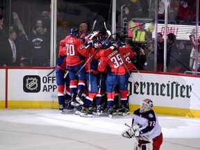Washington Capitals celebrate after Game 5 of an NHL first-round hockey playoff series as Columbus Blue Jackets goaltender Sergei Bobrovsky (72), of Russia, skates by, Saturday, April 21, 2018, in Washington. The Capitals won 4-3 in overtime.