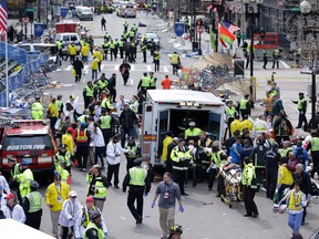 FILE - In this April 15, 2013 file photo, medical workers aid injured people following an explosion at the finish line of the 2013 Boston Marathon in Boston.