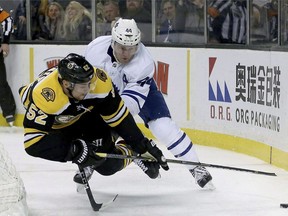Toronto Maple Leafs defenceman Morgan Rielly (44) trips Boston Bruins center Sean Kuraly (52) who was making a play for the puck behind the net during the second period of an NHL hockey game, Saturday, Feb. 3, 2018, in Boston. The Leafs visit the Bruins for Game 1 of their first-round playoff series. The young Leafs set franchise records for points and wins this season, but face a tough test against the Bruins' veteran roster.