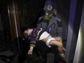 EDS NOTE: GRAPHIC CONTENT - This image released early Sunday, April 8, 2018 by the Syrian Civil Defense White Helmets, shows a rescue worker carrying a child following an alleged chemical weapons attack in the rebel-held town of Douma, near Damascus, Syria. Canada has become the latest to lay the blame for a deadly chemical-weapons attack in Syria last week at Syrian President Bashar al-Assad's doorstep, despite Russian suggestions to the contrary.