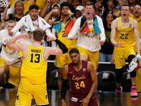Michigan's Moritz Wagner (13) celebrates with his teammates as Loyola-Chicago's Aundre Jackson (24) walks off during the second half in the semifinals of the Final Four NCAA college basketball tournament, Saturday, March 31, 2018, in San Antonio.