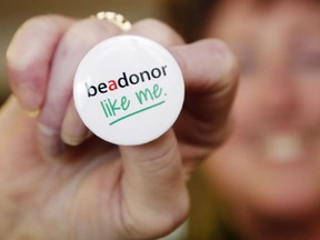 Jacquie Morris holds a button encouraging people to register as potential organ donors Thursday, April 19, 2018 at Belleville General Hospital in Belleville, Ont.