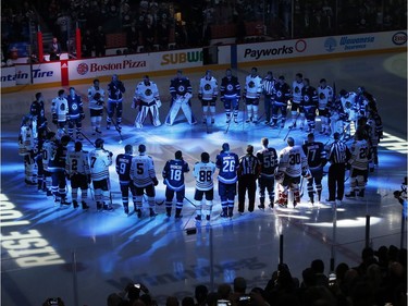 Winnipeg Jets and the Chicago Blackhawks come together at centre ice wearing Broncos on the back of their jerseys for a moment of silence for the Humboldt Broncos bus crash victims before NHL action in Winnipeg on Saturday, April 7, 2018.