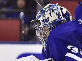 Toronto Maple Leafs goaltender Frederik Andersen (31) takes a puck off his helmet during third period NHL round one playoff hockey action against the Boston Bruins in Toronto on Monday, April 23, 2018.