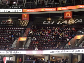 Fans in the upper levels sit in front of seats covered with tarp to reduce the seating capacity in Canadian Tire Centre during the first period of the Senators' home game against the Sabres on Feb. 15.