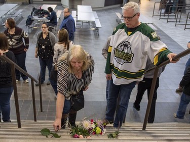 Humboldt mayor Rob Muench, in the Broncos jersey, along with other mourners lays down flowers on the stairs that enter to Elgar Petersen Arena, home of the Humboldt Broncos.