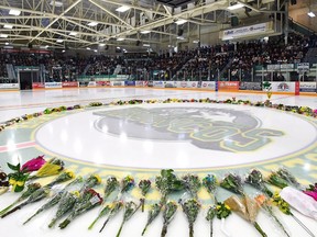 Flowers lie at centre ice as people gather for a vigil at the Elgar Petersen Arena, home of the Humboldt Broncos, to honour the victims of a fatal bus accident in Humboldt, Sask. on Sunday, April 8, 2018. It will take several months to distribute the more than $8 million raised so far for the victims of a fatal bus crash involving the Humboldt Broncos, says the platform hosting the online crowdfunding campaign -- the largest ever in Canada.