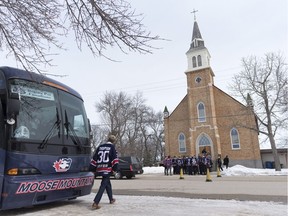 Regina Pat Canadians player Jared Thompson crosses the street to join his teammates before the funeral for Adam Herold at Sacred Heart Church in Montmartre, Sask., on Friday. Herold, a 16-year-old Humboldt Broncos player, was killed in last week's bus crash.