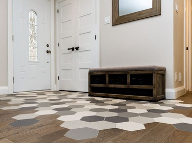 The entryway was made a focal point of the home following renovation. Hexagon-shaped tiles merged with hardwood flooring to create a "splash pad" of sorts to take off shoes.