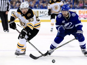 Boston Bruins winger Brad Marchand (left) and Tampa Bay Lightning forward Tyler Johnson fight for the puck during Game 1 of their Eastern Conference second round series on Saturday afternoon at Amalie Arena. (Mike Ehrmann/Getty Images)