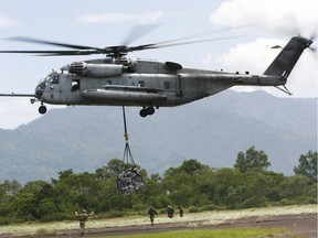 In this Saturday Oct. 10, 2009, file photo, a U.S. military helicopter, the CH-53E Super Stallion, airlifts humanitarian aid to be dropped in affected regions around Pariaman, north of Padang, Indonesia. On Tuesday, April 3, 2018, a CH-53E Super Stallion similar to the one shown went down shortly after 2:30 p.m., during a training mission near El Centro, Calif., a few miles from the U.S.-Mexico border.