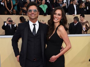 FILE - In this Jan. 21, 2018, file photo, John Stamos, left, and Caitlin McHugh arrive at the 24th annual Screen Actors Guild Awards at the Shrine Auditorium & Expo Hall in Los Angeles. Stamos announced on Instagram the birth of his son, Billy Stamos.