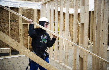 17-year-old Harrison Woods carries lumber into the site.