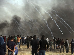 Israeli troops fire teargas at Palestinians during a protest at the Gaza Strip's border with Israel, Friday, April 13, 2018.