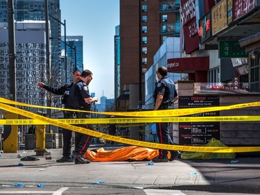 A body lies covered on the sidewalk in Toronto after a van mounted a sidewalk crashing into a number of pedestrians on Monday, April 23, 2018.