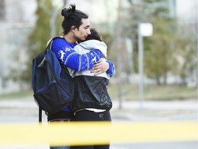 Two people comfort each other in Toronto after a van mounted a sidewalk crashing into a number of pedestrians on Monday, April 23, 2018.