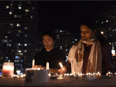 People light candles at a memorial to the victims after a van hit a number of pedestrians on Yonge Street and Finch in Toronto on Monday, April 23, 2018. Ten people died and 15 others were injured when a van mounted a sidewalk and struck multiple pedestrians along a stretch of one of Toronto's busiest streets.THE CANADIAN PRESS/Nathan Denette ORG XMIT: NSD701