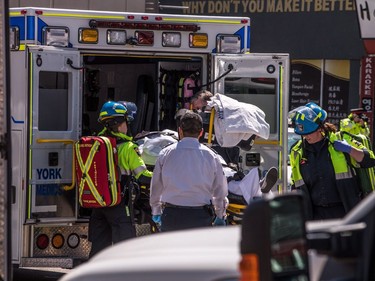 An injured person is put into the back of an ambulance in Toronto after a van mounted a sidewalk crashing into a number of pedestrians on Monday, April 23, 2018.