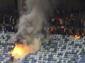 A fire burns in the stands at the Moses Mabhida stedium in Durban, South Africa, Saturday, April 21, 2018, after violence broke out at a soccer game when hundreds of fans ripped up parts of the stadium, invaded the pitch, and assaulted at least one security guard. The incident occurred after the Kaizer Chiefs lost 2-0 to Free State Stars in the semifinals of the Nedbank Cup competition.