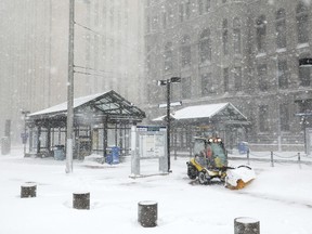 A worker tried to clear snow and ice from the Metro Government Center Plaza station in downtown Minneapolis on Saturday.  Anthony Souffle/Star Tribune via AP