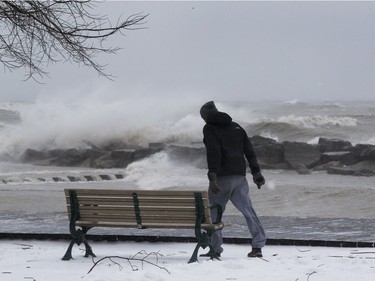 A man navigates 100 km. winds on the boardwalk in The Beach, as an April ice storm hits Toronto with high winds  and the danger of flooding,  on Sunday April 15, 2018.