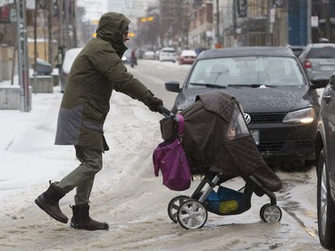 A pedestrian and his passenger navigate an icy Queen Street West, as an April ice storm hits Toronto with high winds  and the danger of flooding,  on Sunday April 15, 2018.