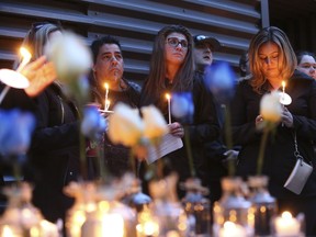 Rob Greco (L) , Steph Borg (very close friend to murder victim and Stephanie Cosentino (R) were part of a  few hundred friends supporters gathered for a  candlelight vigil was held at Dundas Ave W. and Bay St. in honour of van attack murder victim Anne Marie D'Amico  on Thursday April 26, 2018. Jack Boland/Toronto Sun/Postmedia Network