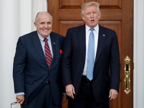 In this Nov. 20, 2016, file photo, then-President-elect Donald Trump, right, and former New York Mayor Rudy Giuliani pose for photographs as Giuliani arrives at the Trump National Golf Club Bedminster clubhouse in Bedminster, N.J.