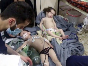 FILE - This Sunday, April. 8, 2018 file image made from video released by the Syrian Civil Defense White Helmets, shows medical workers treating toddlers following an alleged poison gas attack in the opposition-held town of Douma, in eastern Ghouta, near Damascus, Syria. Chemical weapons have killed hundreds of people since the start of Syria's conflict, with the U.N. blaming four attacks on the Syrian government and a fourth on the Islamic State group. A suspected chemical weapons attack occurred over the weekend in the besieged rebel-held town of Douma that was subjected to a resumed government offensive for three days starting Saturday. (Syrian Civil Defense White Helmets via AP, File)