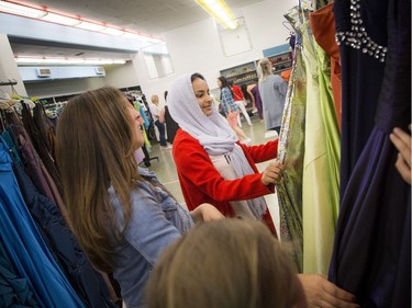 Arwin Awad, 17, checks out some gowns with the help of Mary Ciancibello and her daughter eight-year-old Mikhaela.