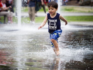 Two and a half year old Cedric Laprise plays in the fountain outside of City Hall Saturday May 26, 2018 during Ottawa Race Weekend.