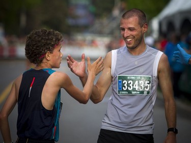 Judd Sjolund (left) congratulates Dorian Baysset at the finish line of the 10K race Saturday May 26, 2018 at Ottawa Race Weekend.