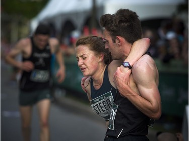 Molly Steer gets a little help on the finish line from Brett Crowley after finishing the 10K race Saturday May 26, 2018 at Ottawa Race Weekend.