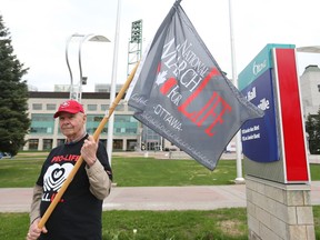 Francis J. (Frank) Barrett holds a pro-life flag in front of Ottawa City Hall, May 10, 2018.  Photo by Jean Levac/Postmedia 129082