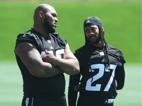 Bruce Gaston Jr., left, chats with defensive back Sherrod Baltimore during Redblacks practice on Thursday morning. Jean Levac/Postmedia