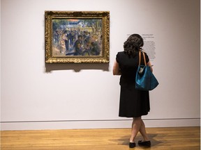 A woman views Le Moulin de la Galette by Pierre Auguste Renoir, 1875-76, which is part of Impressionist Treasures: The Ordrupgaard Collection, at the National Gallery of Canada.