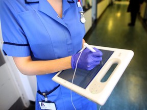 A nurse uses a wireless electronic tablet to order medicines from the pharmacy at The Queen Elizabeth Hospital on March 16, 2010 in Birmingham, England.