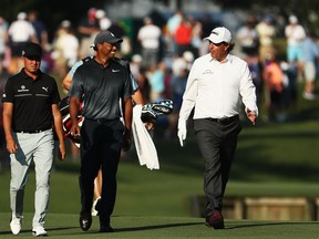 Rickie Fowler of the United States, Tiger Woods of the United States and Phil Mickelson of the United States walk on the tenth hole during the second round of THE PLAYERS Championship on the Stadium Course at TPC Sawgrass on May 11, 2018 in Ponte Vedra Beach, Florida.