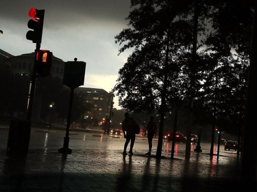 WASHINGTON, DC - MAY 14: People stand under a tree as rain starts to fall as a severe thunderstorm passes over the U.S. Capitol, on May 14, 2018 in Washington, DC. The area was hit with heavy rain and high winds from the early evening storm.