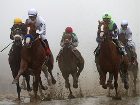 Justify #7 ridden by jockey Mike Smith leads the field in the first pass the 143rd running of the Preakness Stakes at Pimlico Race Course on May 19, 2018 in Baltimore, Maryland.