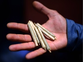 A man shows marijuana joints.