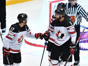 Canada's Connor McDavid (L) celebrates with Canada's Aaron Ekblad after he scored the winning goal 2:1 during the overtime of the group B match Canada vs Latvia of the 2018 IIHF Ice Hockey World Championship at the Jyske Bank Boxen in Herning, Denmark, on May 14, 2018.