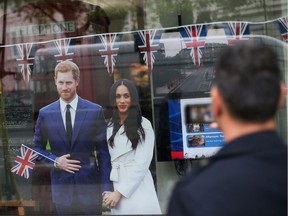 A pedestrian takes a photograph of memorabilia celebrating the forthcoming wedding of Britain's Prince Harry and his fiancee, US actress Meghan Markle, in a gift shop window in central London.